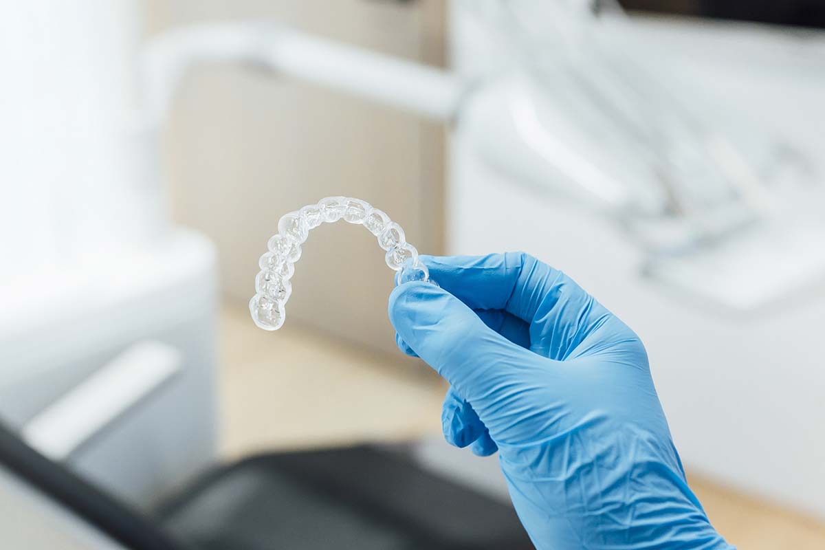 Dr. Klassen holding a set of Invisalign clear aligners for a patient at W Dental in Willow Park, TX